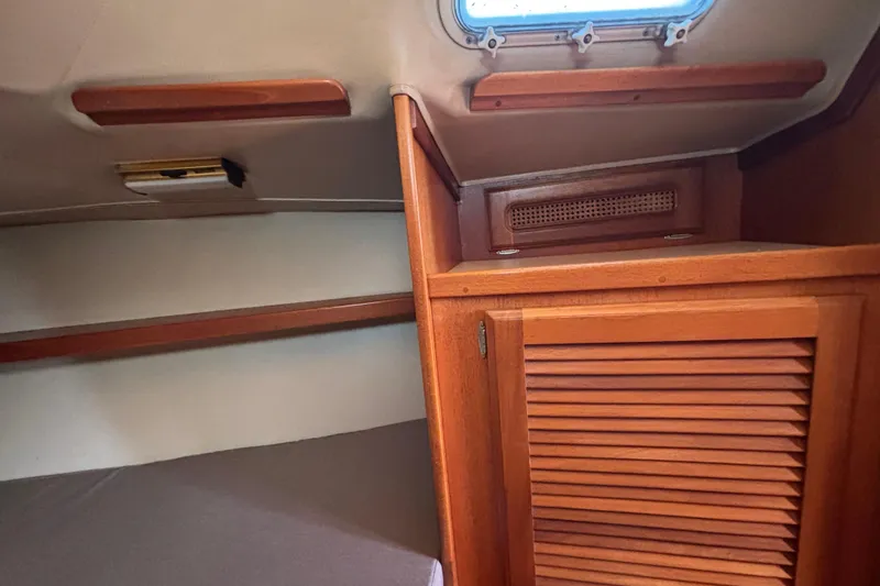 Slide: The Image of Interior of 1979 Islander Peterson 40 sailboat with wooden cabinetry and small window. - 55