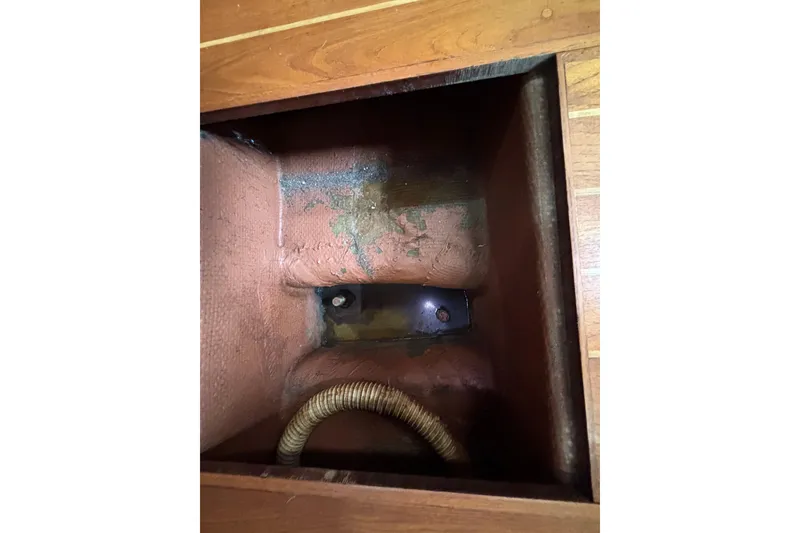 Slide: The Image of Bilge compartment of 1979 Islander Peterson 40 sailboat with visible hose and wood flooring. - 64