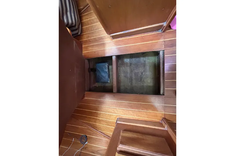 Slide: The Image of Interior view of 1979 Islander Peterson 40 sailboat with wooden flooring and open hatch. - 66