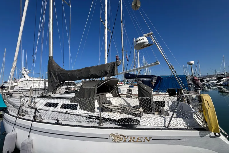 Slide: The Image of 1979 Islander Peterson 40 sailboat docked in marina under clear blue sky. - 7
