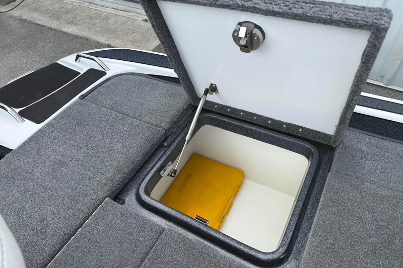 Slide: The Image of Open storage compartment in 2023 Phoenix 921 Elite II boat, featuring a yellow container. - 18