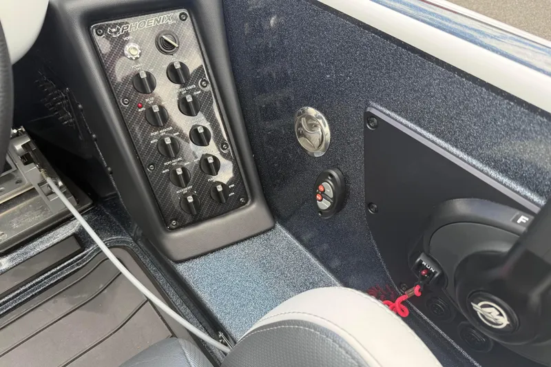 Slide: The Image of 2023 Phoenix 921 Elite II boat dashboard with control panel and switches. - 23