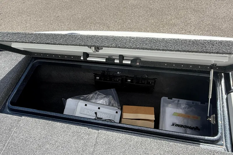 Slide: The Image of Open storage compartment in a 2023 Phoenix 921 Elite II boat, containing various equipment. - 35