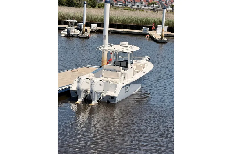 Slide: The Image of 2025 Sea Hunt Ultra 275 SE boat docked on a sunny day. - 10