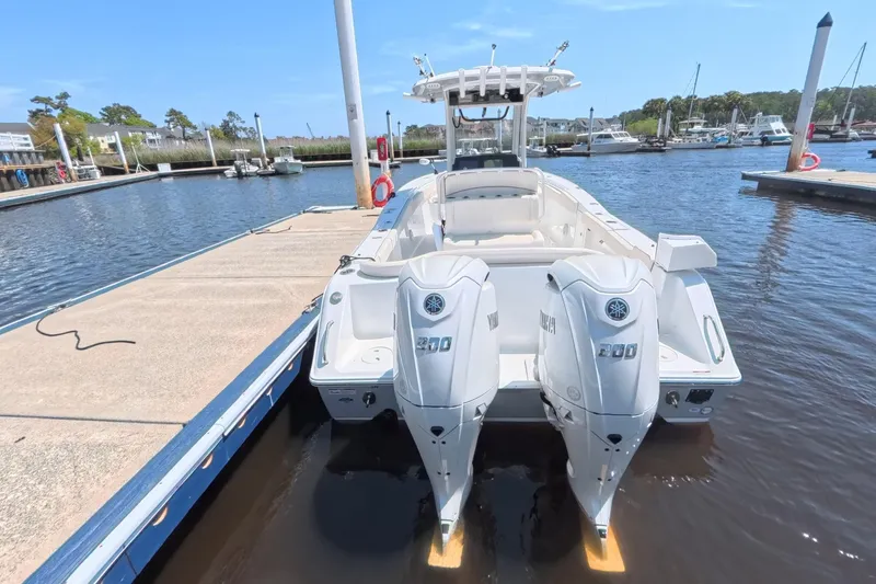 Slide: The Image of 2025 Sea Hunt Ultra 275 SE boat on calm water with trees in the background. - 2