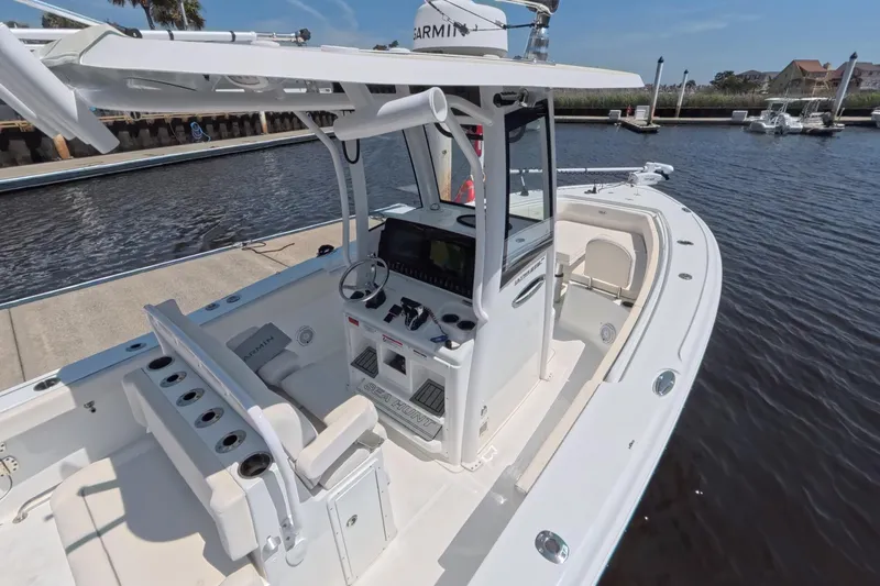 Slide: The Image of 2025 Sea Hunt Ultra 275 SE boat on calm water under clear blue sky. - 3