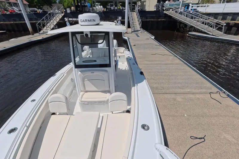 Slide: The Image of 2025 Sea Hunt Ultra 275 SE cruising on a sunny day, with flags waving. - 7