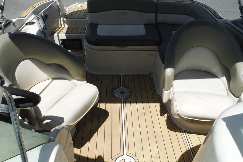 Slide: The Image of 2005 Sea Ray 220 Sundeck interior with cushioned seating and wooden flooring. - 13