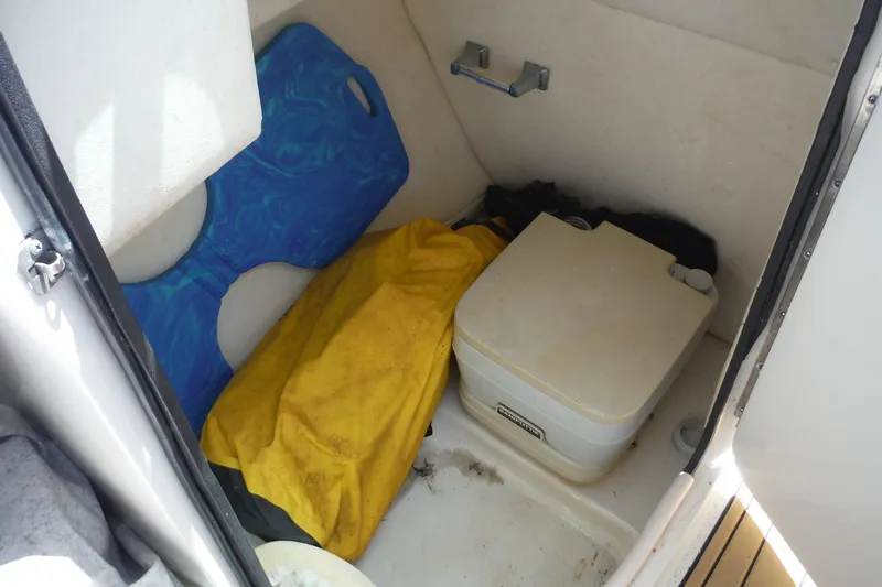 Slide: The Image of Interior of 2005 Sea Ray 220 Sundeck with portable toilet and storage items. - 16