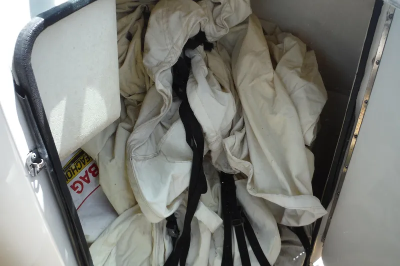 Slide: The Image of Storage compartment on a 2005 Sea Ray 220 Sundeck with life jackets and safety gear. - 17