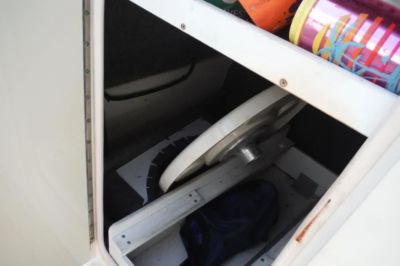 Slide: The Image of Storage compartment in a 2005 Sea Ray 220 Sundeck boat with colorful items. - 26