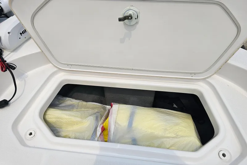 Slide: The Image of Storage compartment on 2022 Yamaha Boats 190 FSH Sport, containing wrapped items. - 20