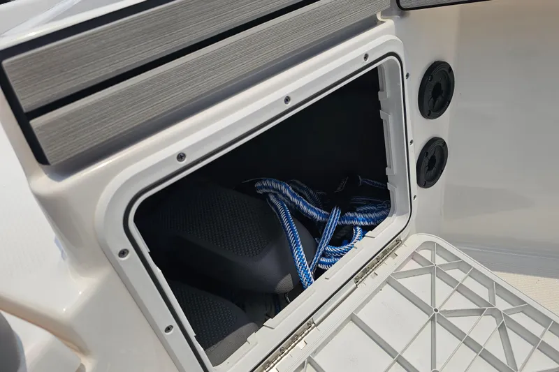 Slide: The Image of Storage compartment on 2022 Yamaha Boats 190 FSH Sport with blue rope inside. - 28