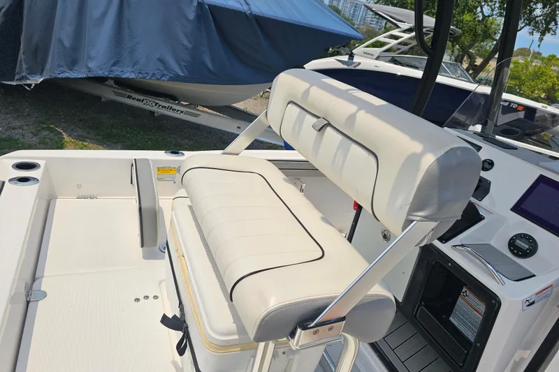 Slide: The Image of 2022 Yamaha Boats 190 FSH Sport interior with white seating and control panel. - 35