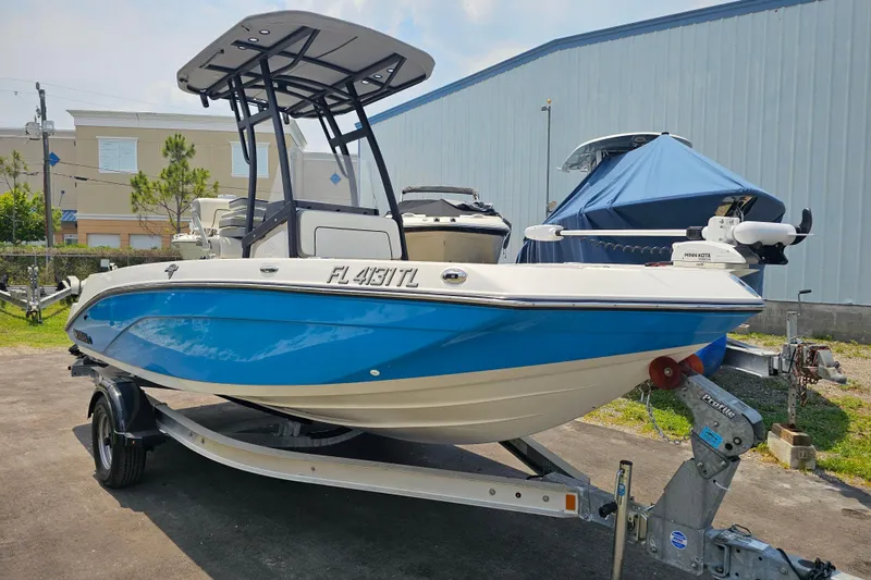 Slide: The Image of 2022 Yamaha Boats 190 FSH Sport in blue, parked on a trailer outdoors. - 5