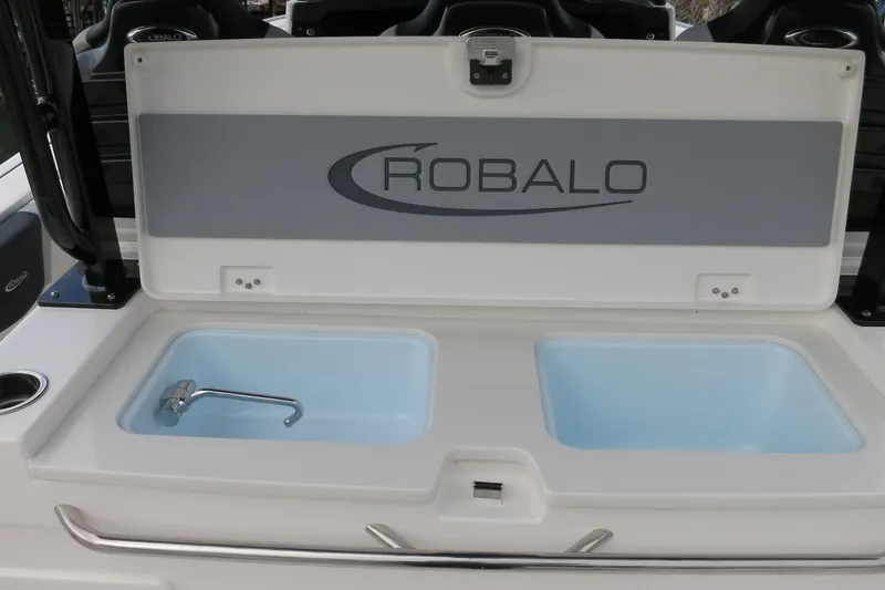 Slide: The Image of 2026 Robalo R300 Center Console boat with open storage compartment. - 25