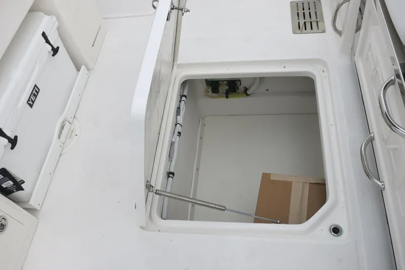Slide: The Image of Open storage compartment on 2026 Robalo R300 Center Console boat deck. - 26