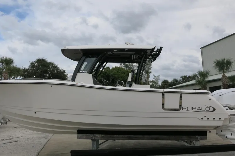 Slide: The Image of 2026 Robalo R300 Center Console boat displayed outdoors on a cloudy day. - 3