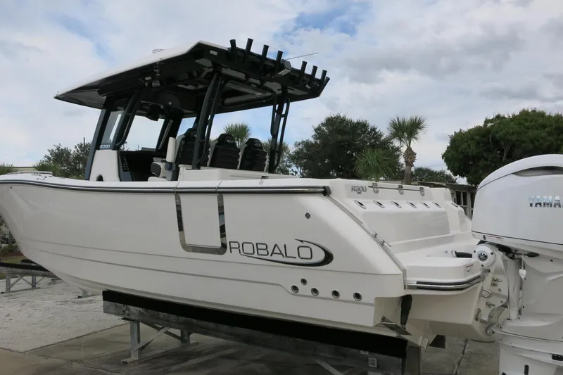Slide: The Image of 2026 Robalo R300 Center Console boat with Yamaha engine, docked outdoors. - 4