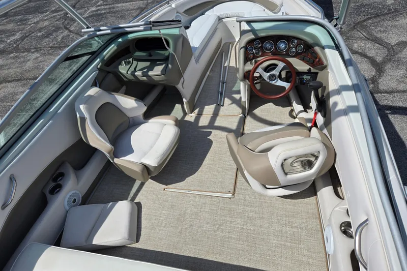 Slide: The Image of 2014 Crownline 21 SS boat interior with beige seating and modern dashboard. - 14