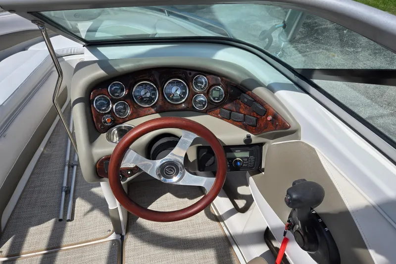 Slide: The Image of 2014 Crownline 21 SS boat dashboard with wood accents and steering wheel. - 15