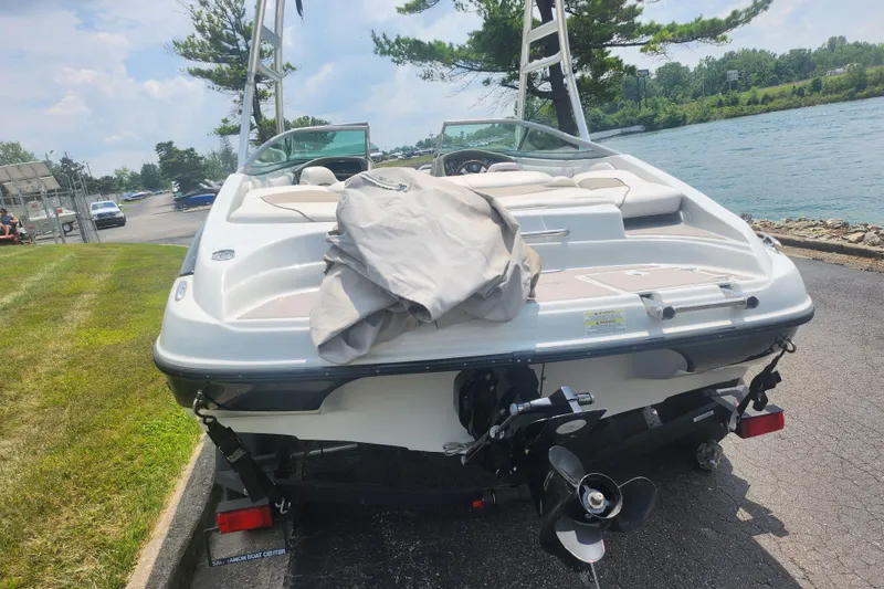 Slide: The Image of 2014 Crownline 21 SS boat parked near a scenic waterfront. - 2