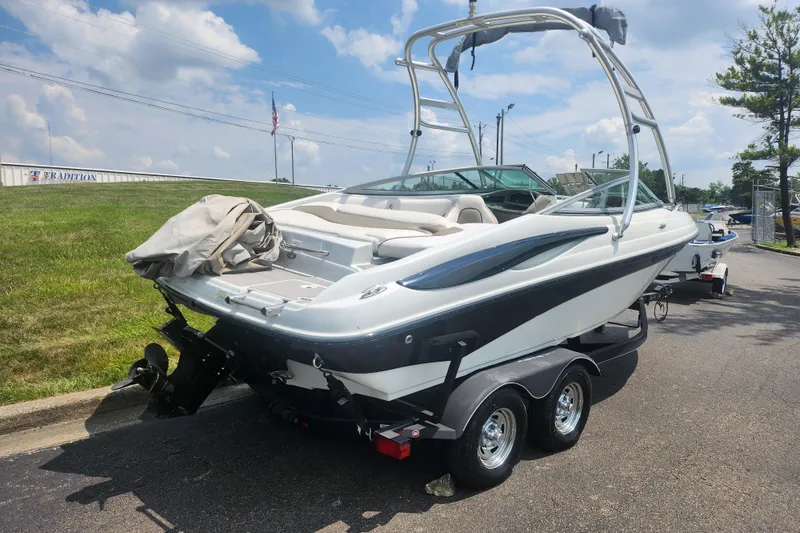Slide: The Image of 2014 Crownline 21 SS boat on trailer, parked outdoors under a cloudy sky. - 3