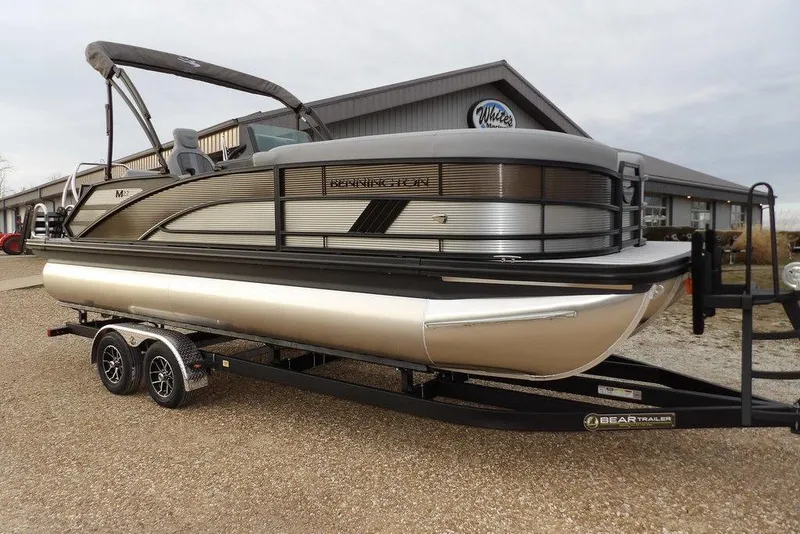 The Image of 2026 Bennington M L-Bench 22 ML pontoon boat on trailer, parked outdoors. - 1