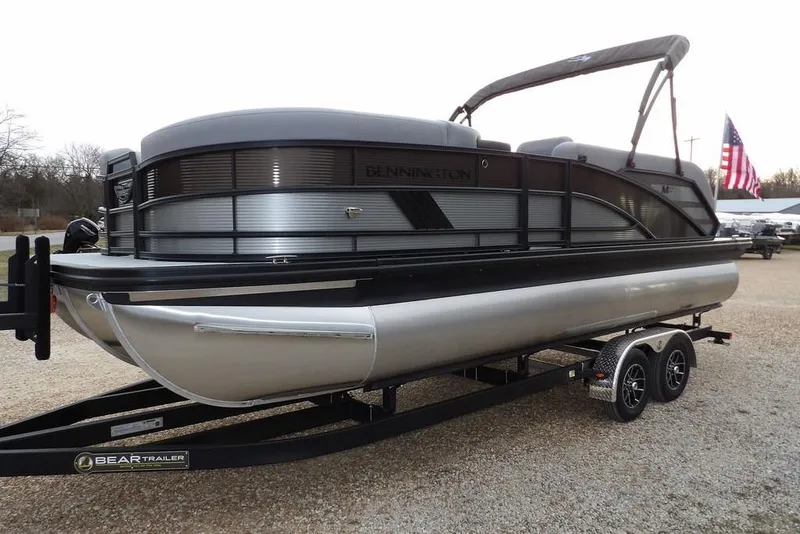 Slide: The Image of 2026 Bennington M L-Bench 22 ML pontoon boat on trailer, parked outdoors. - 4