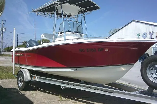 Slide: The Image of 2010 Sea Hunt Triton 202 boat on trailer, red and white hull, parked outdoors. - 10