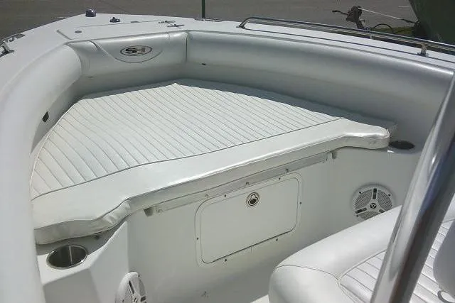 Slide: The Image of 2010 Sea Hunt Triton 202 boat interior with white cushioned seating and storage compartment. - 15