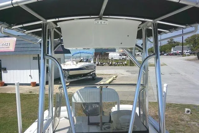 Slide: The Image of 2010 Sea Hunt Triton 202 boat with T-top and console, parked outdoors. - 17