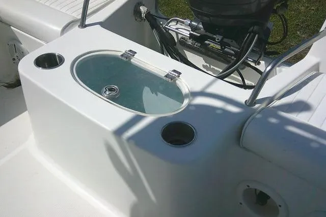 Slide: The Image of Livewell on 2010 Sea Hunt Triton 202 boat, featuring cup holders and motor controls. - 23