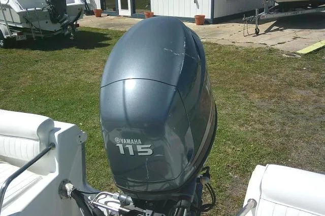 Slide: The Image of Yamaha 115 outboard motor on a 2010 Sea Hunt Triton 202 boat, parked on grass. - 25