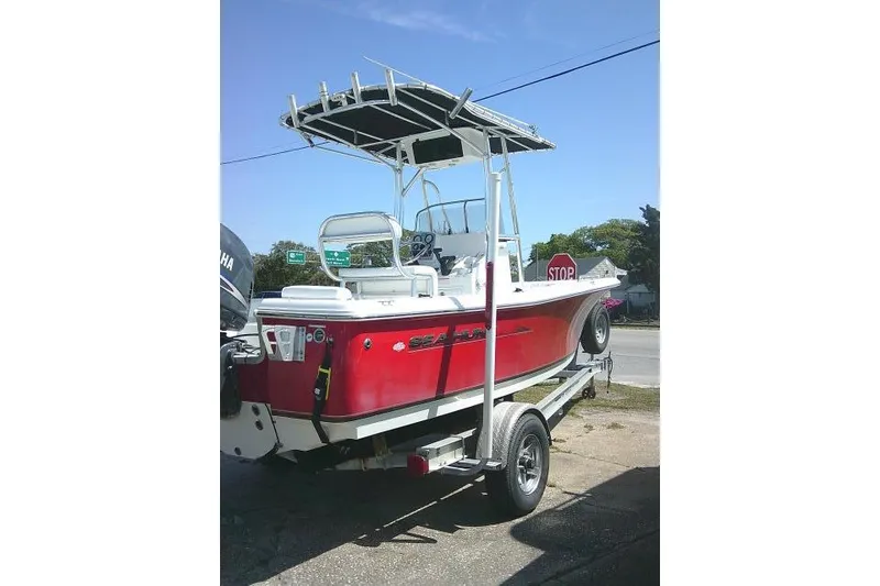 Slide: The Image of Red 2010 Sea Hunt Triton 202 boat on trailer, featuring T-top and Yamaha outboard motor. - 6