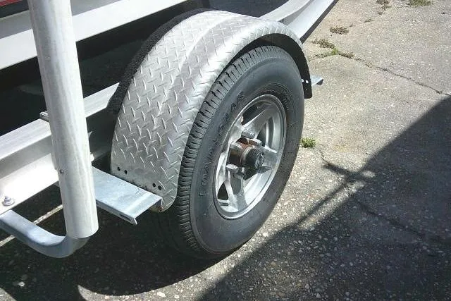 Slide: The Image of Trailer wheel of a 2010 Sea Hunt Triton 202 boat on pavement. - 7