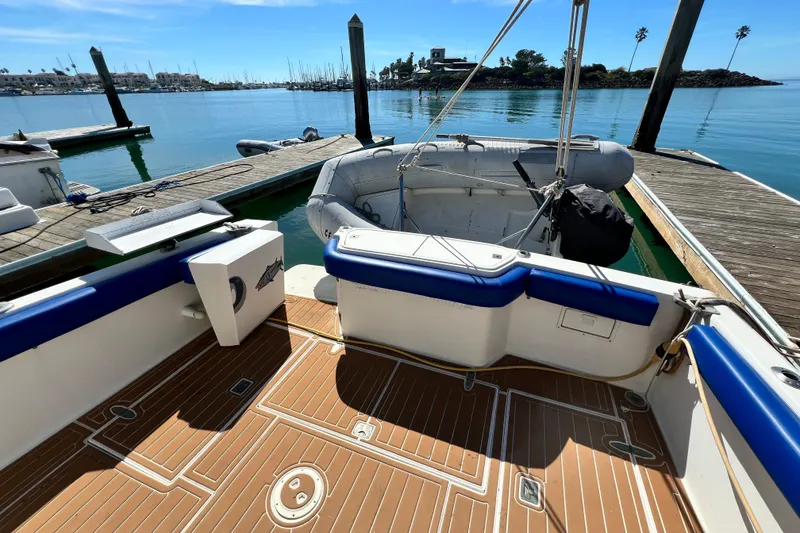 Slide: The Image of 1990 Mediterranean 38 Sport Fisher boat docked, featuring a spacious deck and inflatable dinghy. - 14