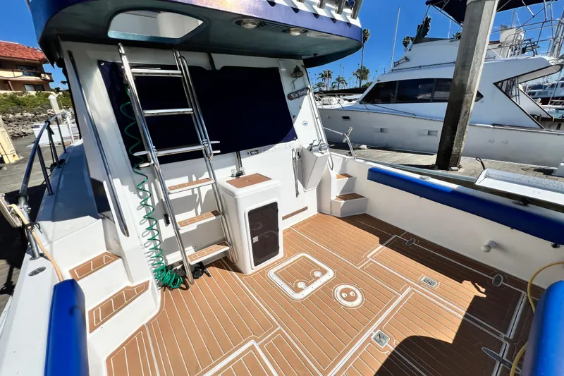 Slide: The Image of 1990 Mediterranean 38 Sport Fisher boat deck with ladder and teak flooring. - 16