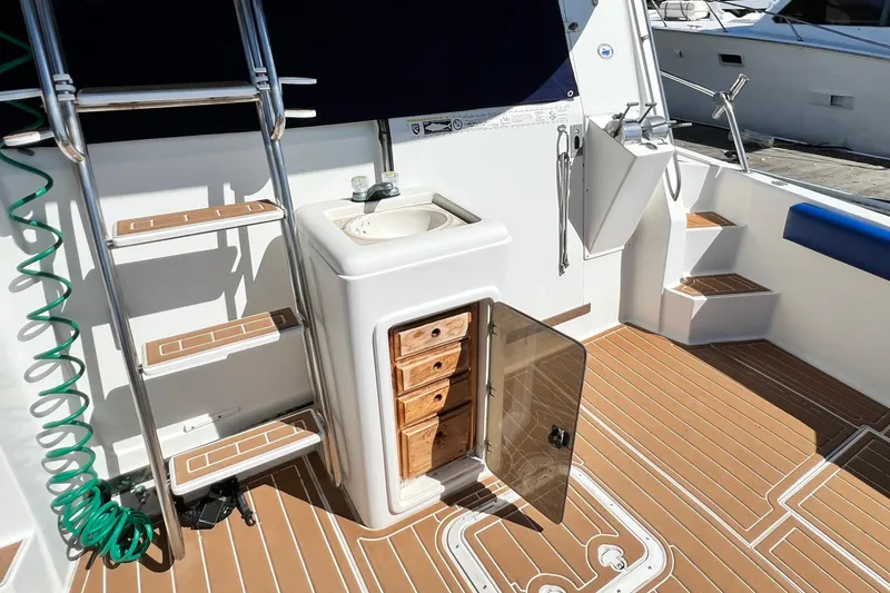 Slide: The Image of 1990 Mediterranean 38 Sport Fisher boat interior with sink, storage, and ladder on teak deck. - 17