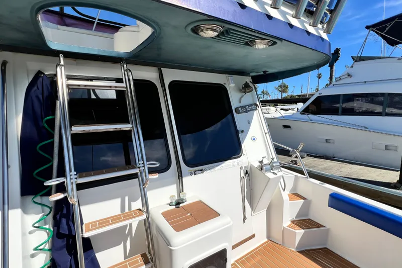 Slide: The Image of 1990 Mediterranean 38 Sport Fisher boat deck with ladder and seating, docked at marina. - 33