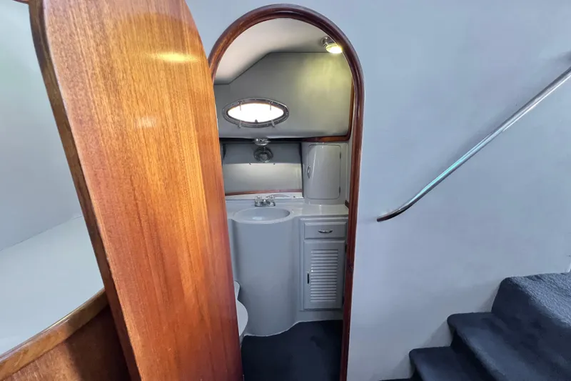 Slide: The Image of Interior of 1990 Mediterranean 38 Sport Fisher yacht, featuring compact bathroom with wooden accents. - 39