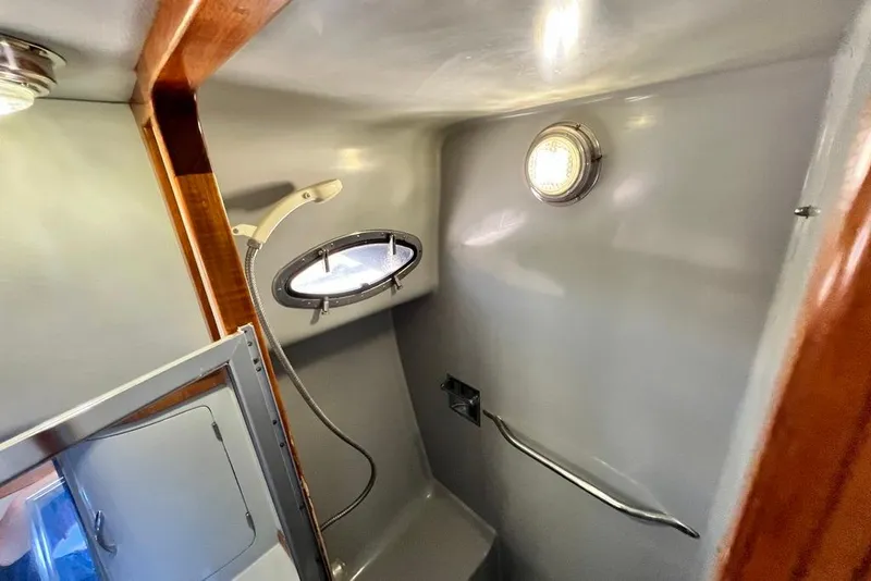 Slide: The Image of Interior of 1990 Mediterranean 38 Sport Fisher boat bathroom with porthole and shower. - 42