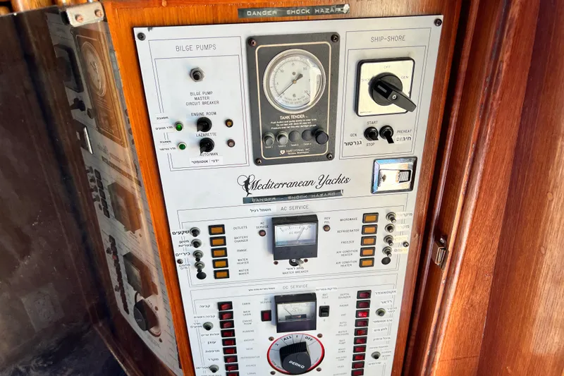 Slide: The Image of Control panel of a 1990 Mediterranean 38 Sport Fisher yacht with various switches and gauges. - 49
