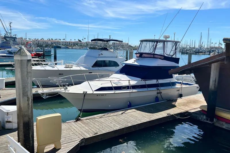 Slide: The Image of 1990 Mediterranean 38 Sport Fisher docked at a marina under clear blue skies. - 6