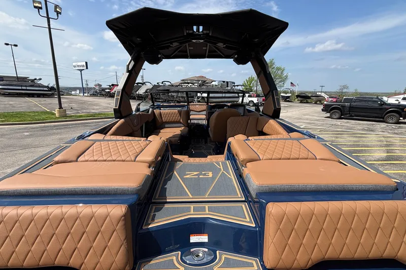 Slide: The Image of 2026 Tigé Z3 boat with luxurious tan seating and sleek design in a parking lot. - 11