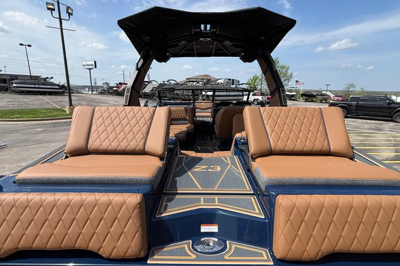 Slide: The Image of 2026 Tigé Z3 boat with luxurious tan seating and sleek design in a parking lot. - 14