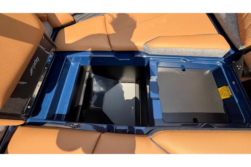 Slide: The Image of 2026 Tigé Z3 boat interior storage compartment with tan seating and blue trim. - 68