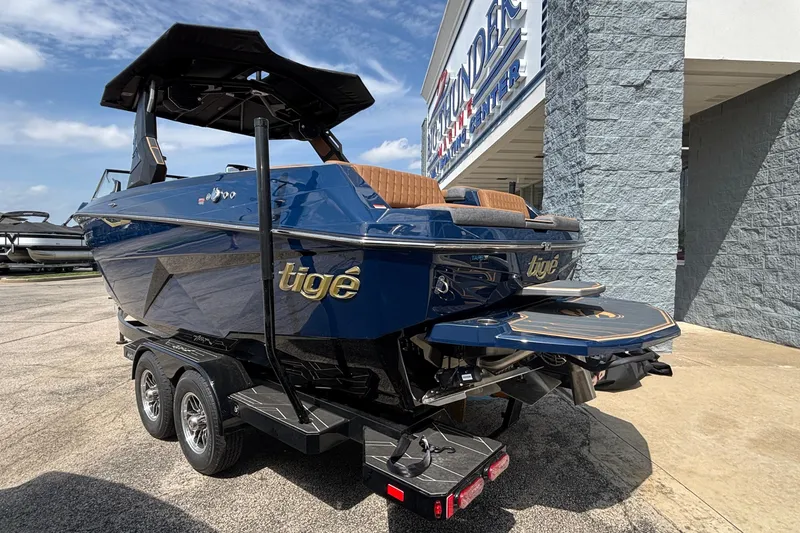 Slide: The Image of 2026 Tigé Z3 boat in blue, parked outside a marine center on a sunny day. - 8