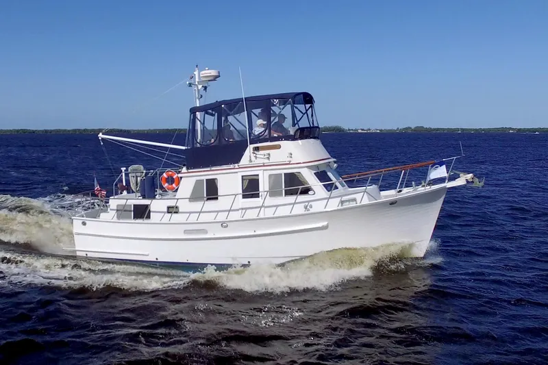 The Image of 1999 Monk 36 Trawler cruising on open water under clear blue sky. - 0