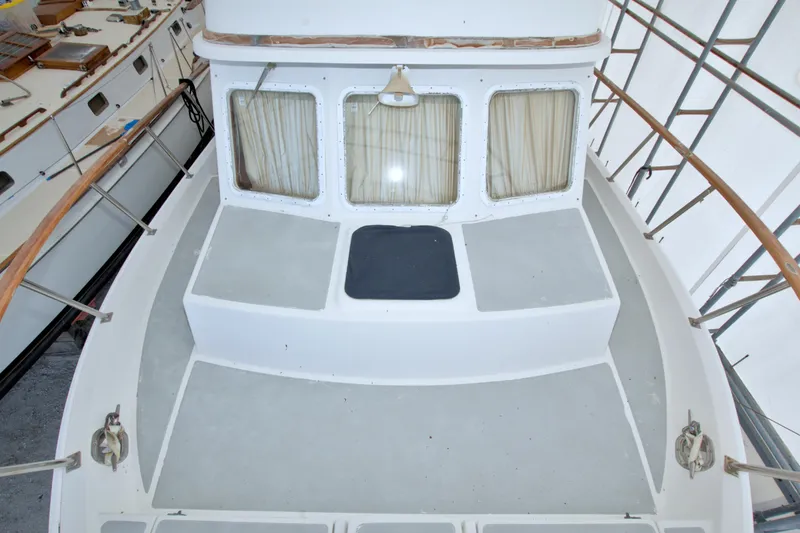 Slide: The Image of 1999 Monk 36 Trawler deck with wooden railings and curtained windows. - 13